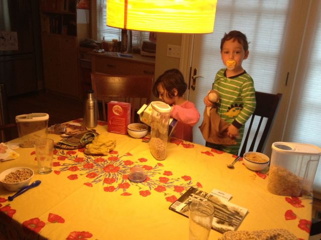 Four bowls of cereal and milk, four spoons, biscuits, and glasses of water, all on their own.